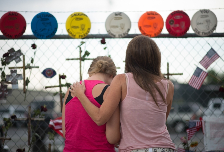 Carrie Parker-Morena (left) is consoled by her aunt, Janae Parker Haremza. Wade Parker, the brother of Parker-Morena and the nephew of Haremza, was among the 19 firefighters killed June 30 in the Yarnell Hill Fire. (Aaron Lavinsky/The Arizona Republic)