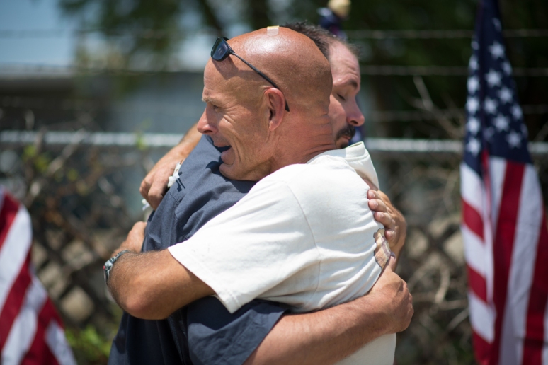  Chris Lyons shares an emotional moment with Steve Fine after setting up 19 American flags at a memorial at the Granite Mountain Hot Shot's fire station in Prescott on Wednesday, July 3, 2013.  (Aaron Lavinsky/The Arizona Republic)