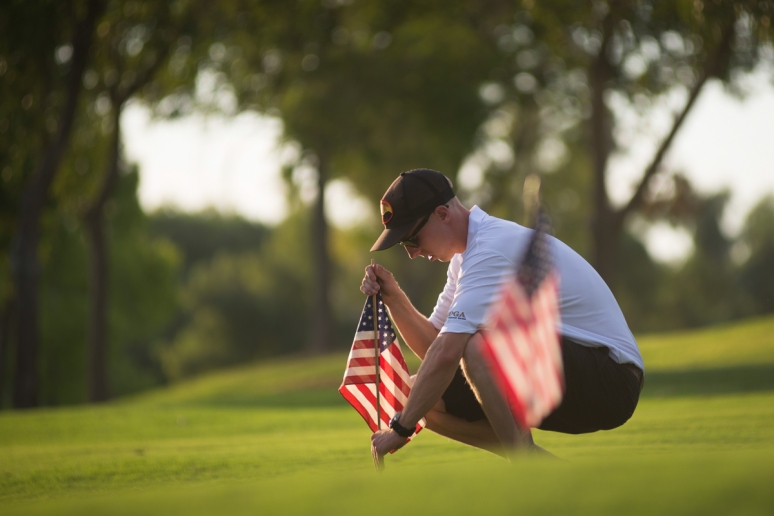 Brendan McDonough, the surviving 20th member of the Granite Mountain Hotshots, makes sure that an American flag stands upright on a practice green at Gainey Ranch Golf Club in Scottsdale on Aug. 2, 2013 (Aaron Lavinsky/The Arizona Republic)
